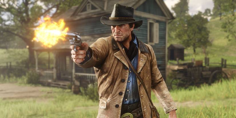 A screenshot of Arthur Morgan shooting his gun in front of a house in Red Dead Redemption 2.