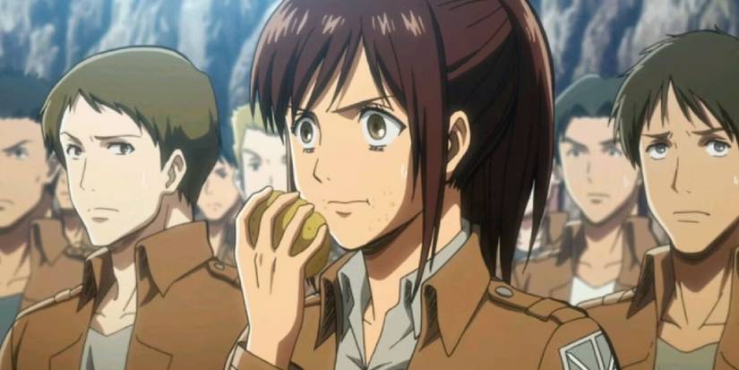 Sasha munching on a potato while standing in line with the other soldiers.