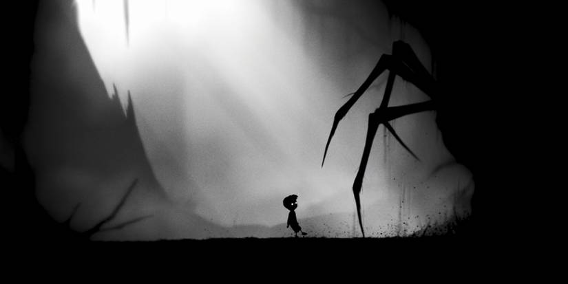 The boy stares up at an emerging giant spider in a dark and barren landscape.