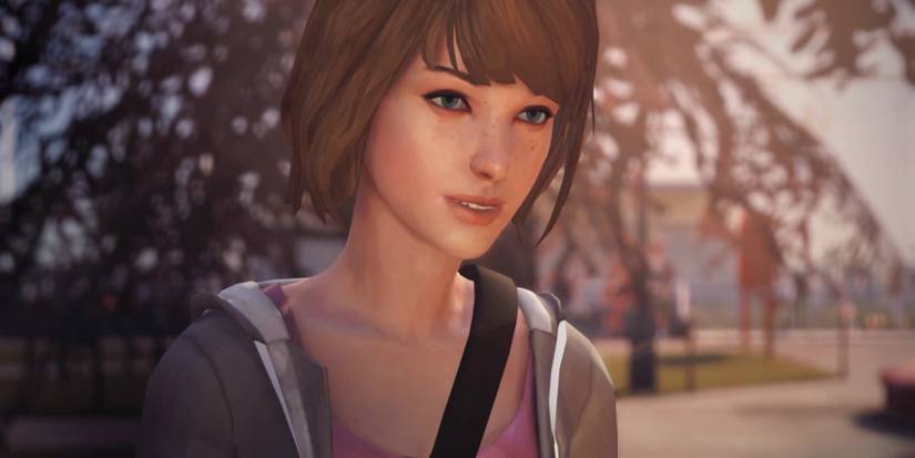 Protagonist Max Caulfield stands smiling against the backdrop of a leafy school