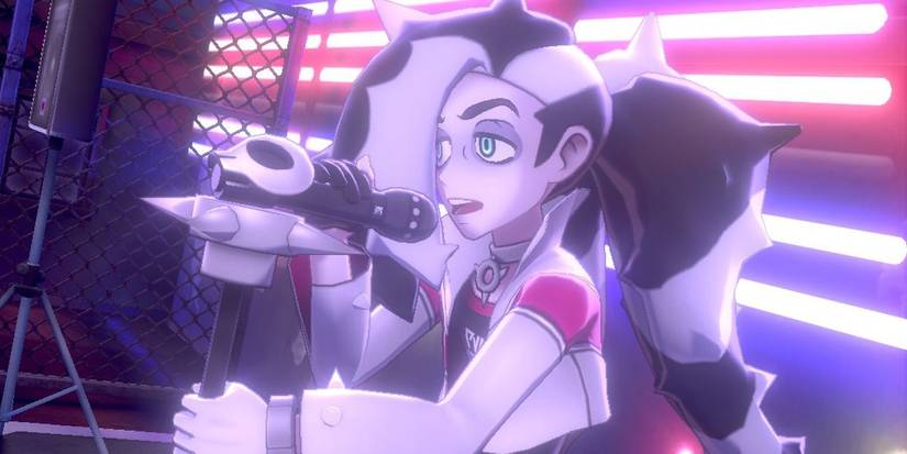 Piers sings a rock song in his gym, holding onto the microphone