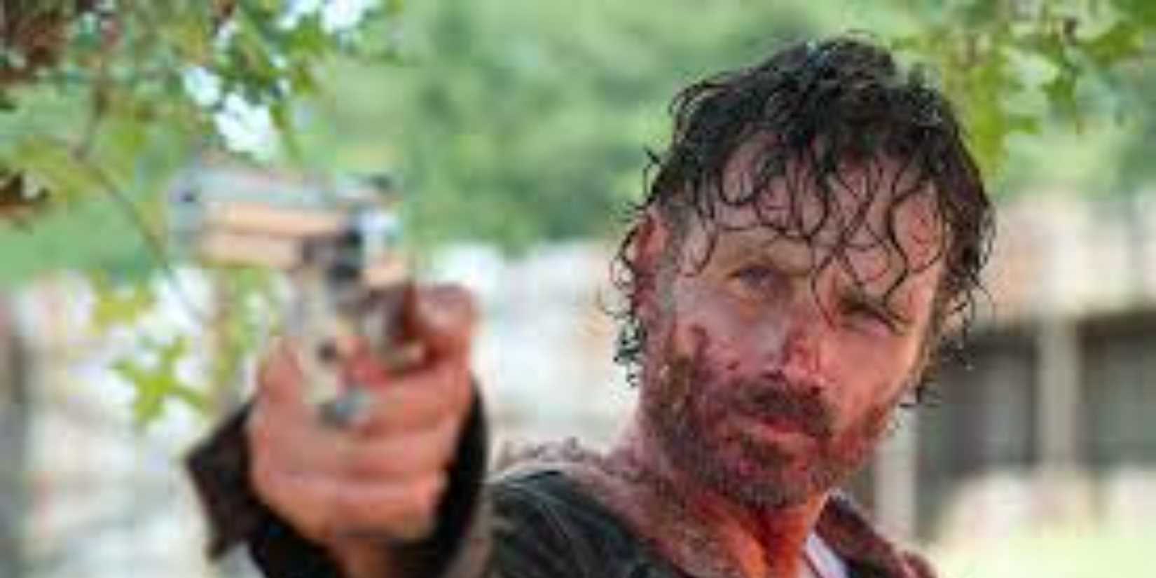 rick grimes with blood on his face, holding a gun walking dead