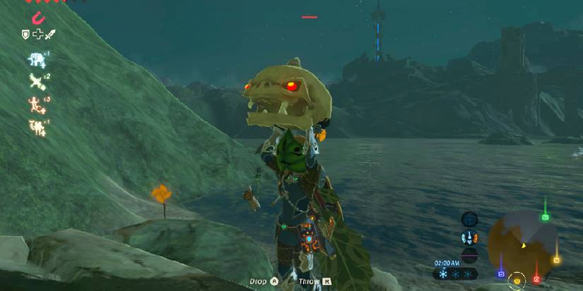 Link holding a Stalkoblin Head with glowing red eyes above himself at night.