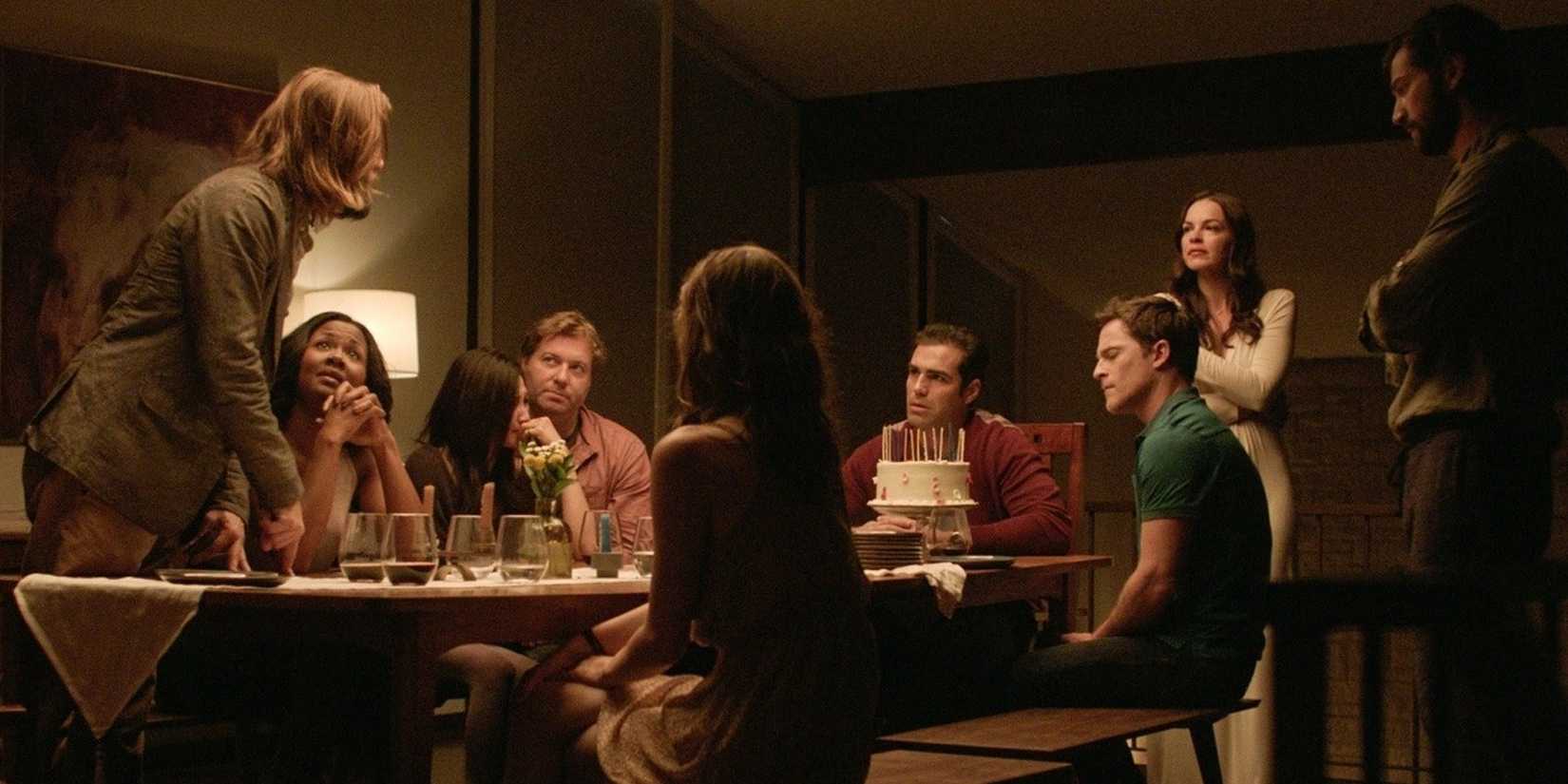 Party guests are talking at the dinner table in The Invitation.