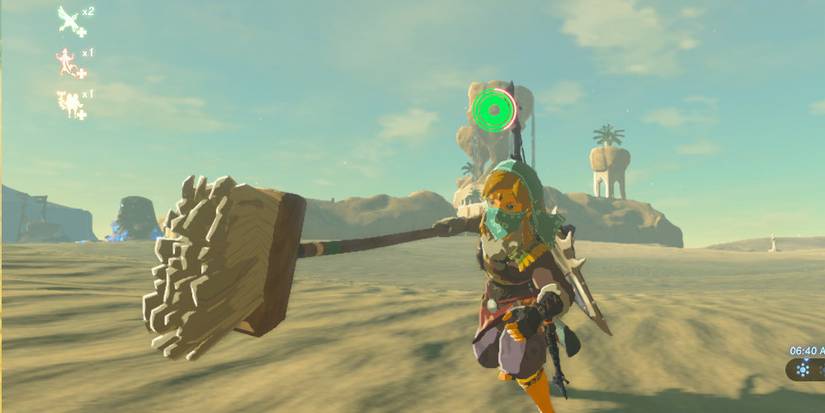 Link thrusting a wooden mop forward in the desert.