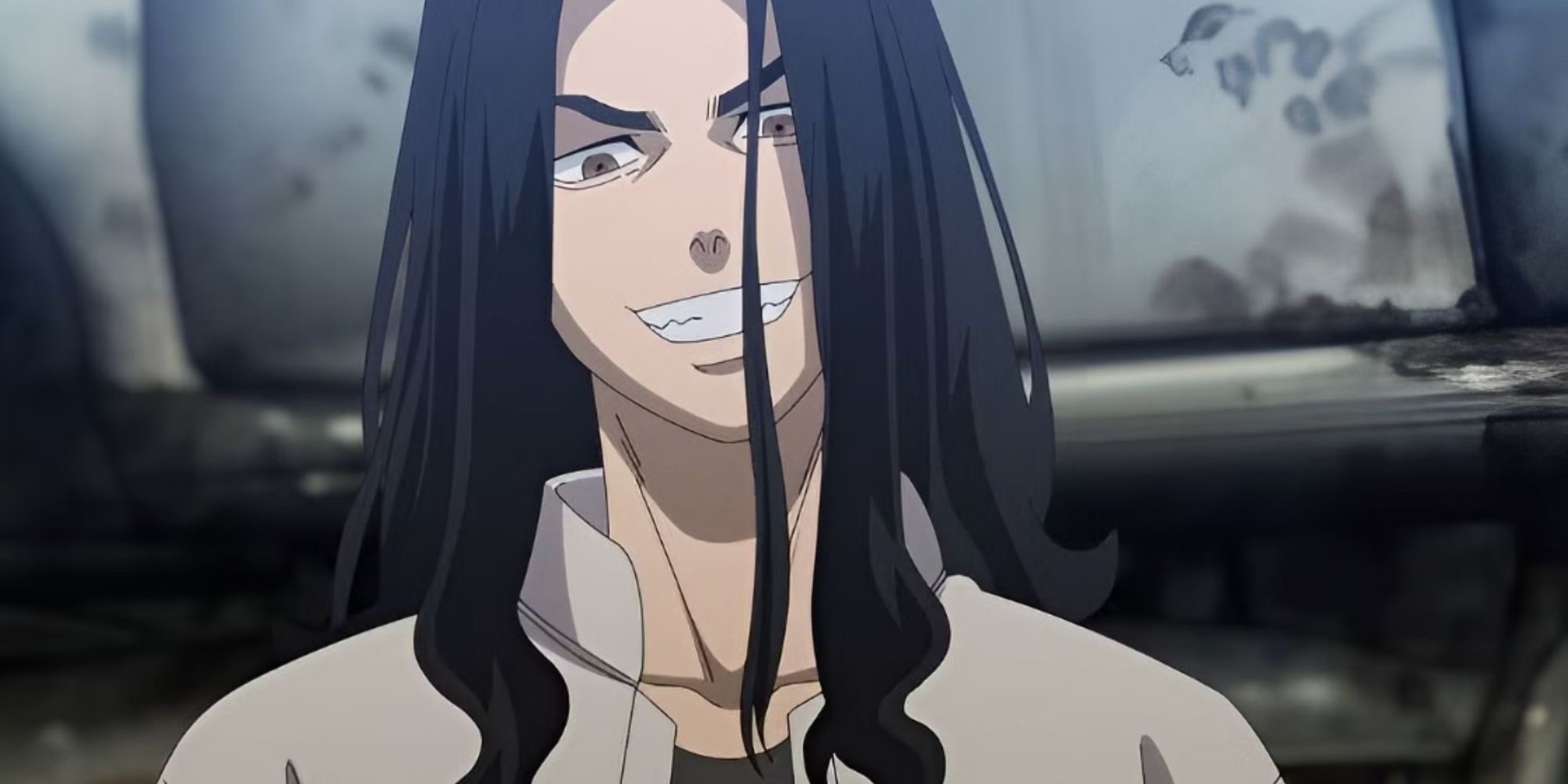 a boy with long black hair smiles