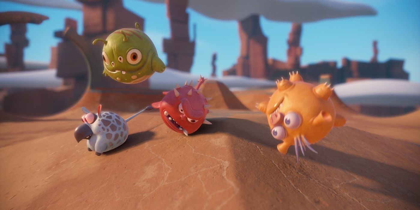 Four ball-like creatures roll around in a desert area in Deformers