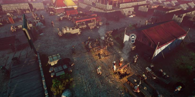 A top down view of a military camp with fire cooking food and people standing around different parts of the camp in Expeditions: Rome