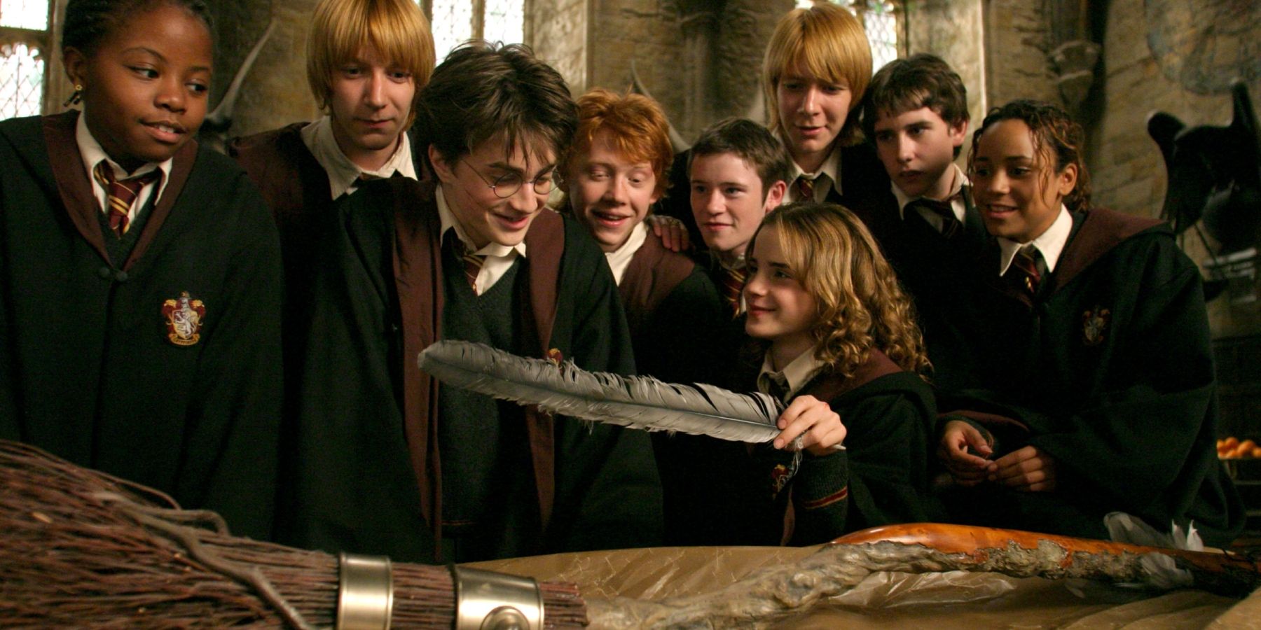 Harry, Ron, Hermione and classmates looking at the Firebolt broomstick in Harry Potter