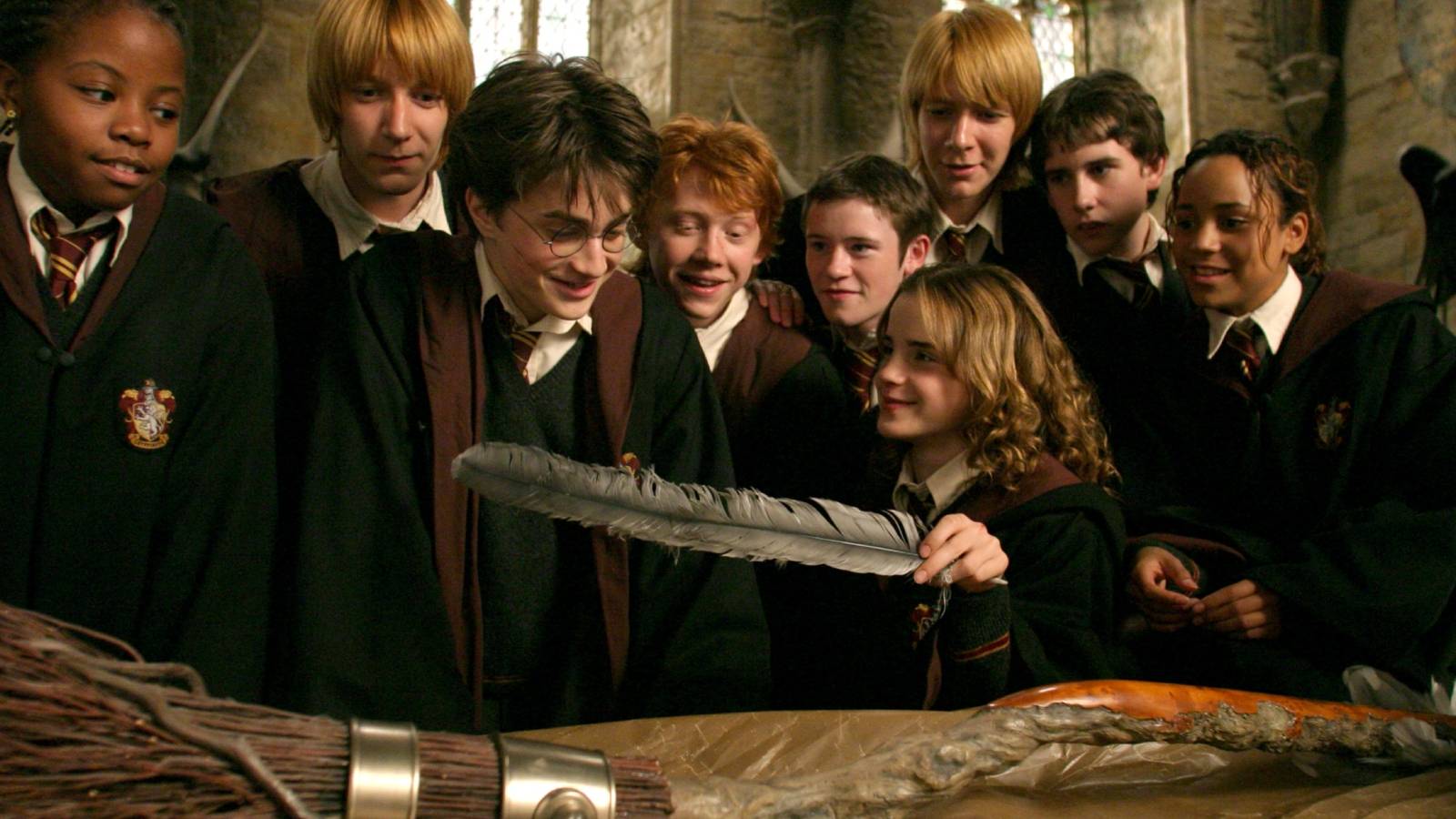 Harry, Ron, Hermione and classmates looking at the Firebolt broomstick in Harry Potter