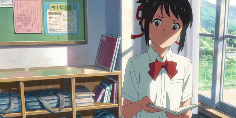 a girl stands n a classroom holding a book