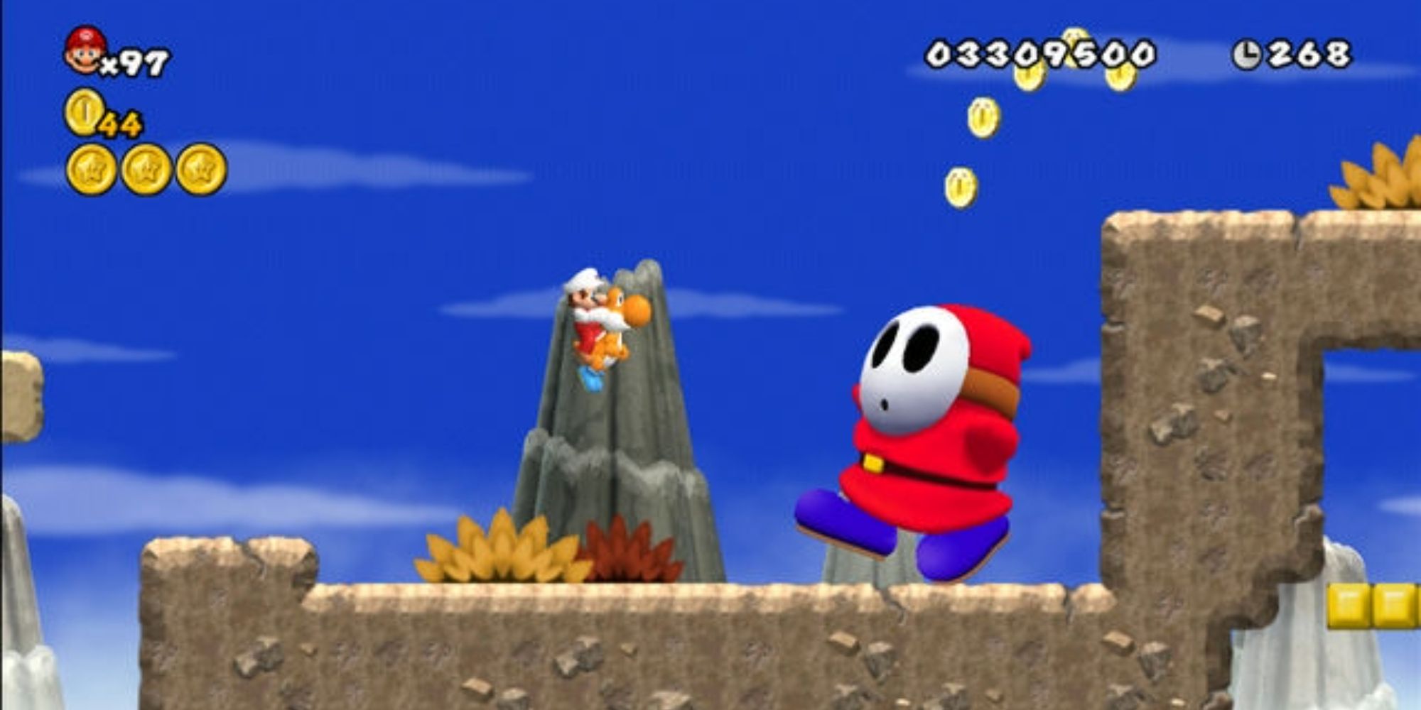 Mario on an orange Yoshi in front of a giant Shy Guy