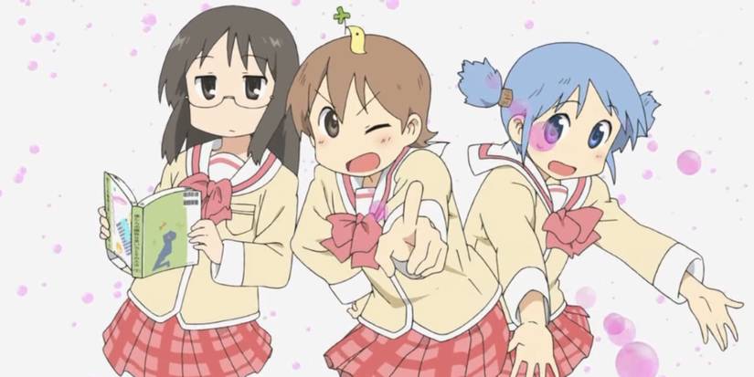 three girls stand together, one reads a book, and one points towards us