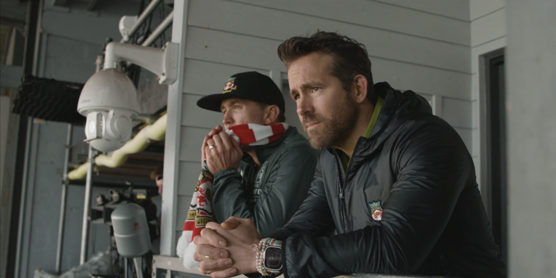 Ryan Reynolds and Rob McElhenney looking out from Wrexham stands