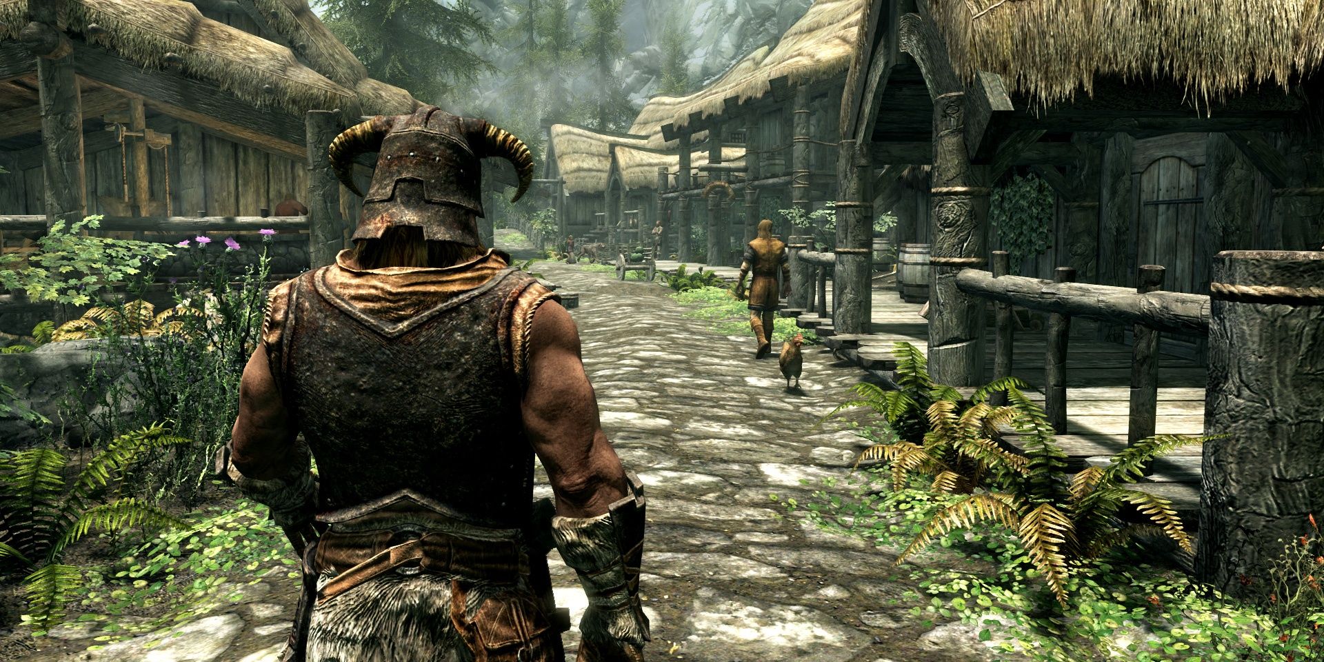 The player walking into a town while an individual and chicken walk on the other side in The Elder Scrolls 5: Skyrim