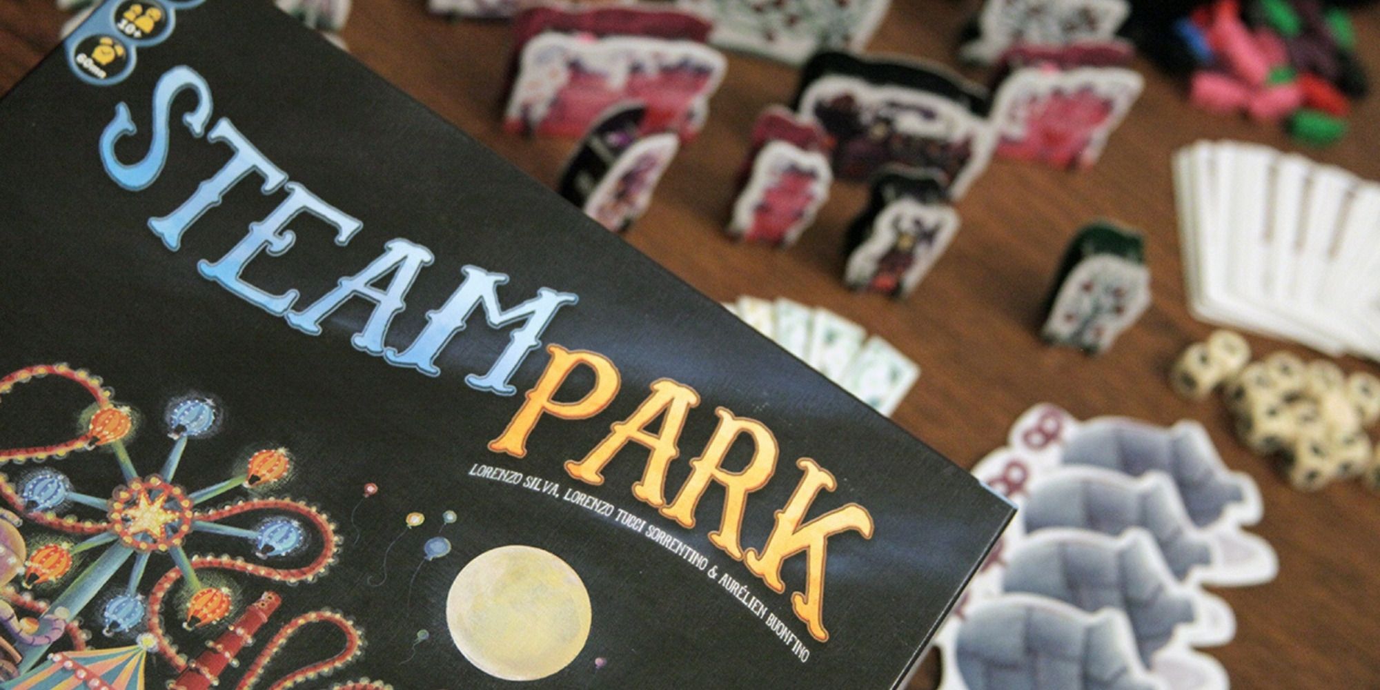 A photo of the Steam Park board game, showcasing coal-powered amusement park rides and game pieces.