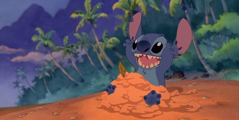 An image of Stitch playing with sand by the beach