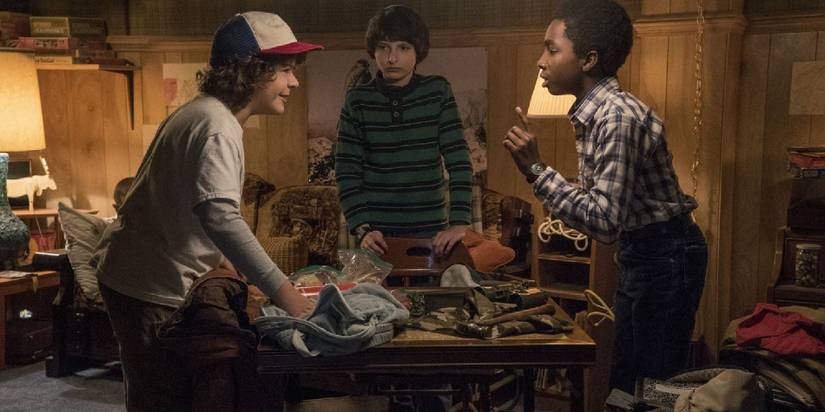 Stranger Things kids gathered around a table with tension.
