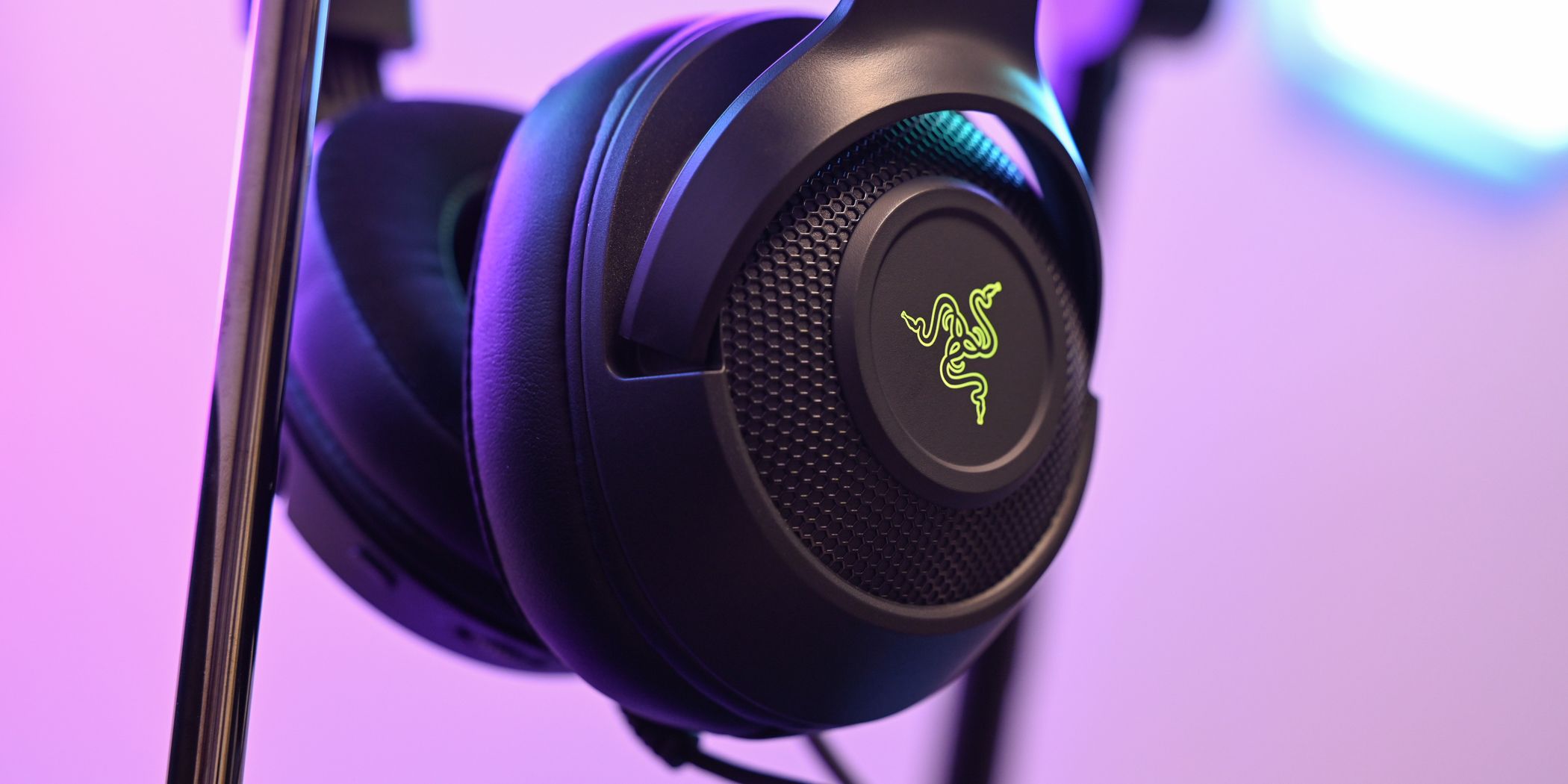 The Razer Kraken V3 X Headset on a headphone stand with the Razer logo illuminated green