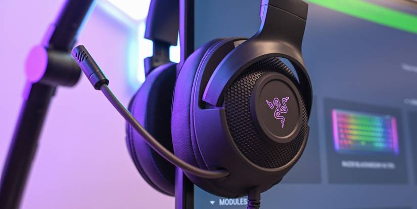 The Razer Kraken V3 X Headset with the logo illuminated purple resting on a computer monitor