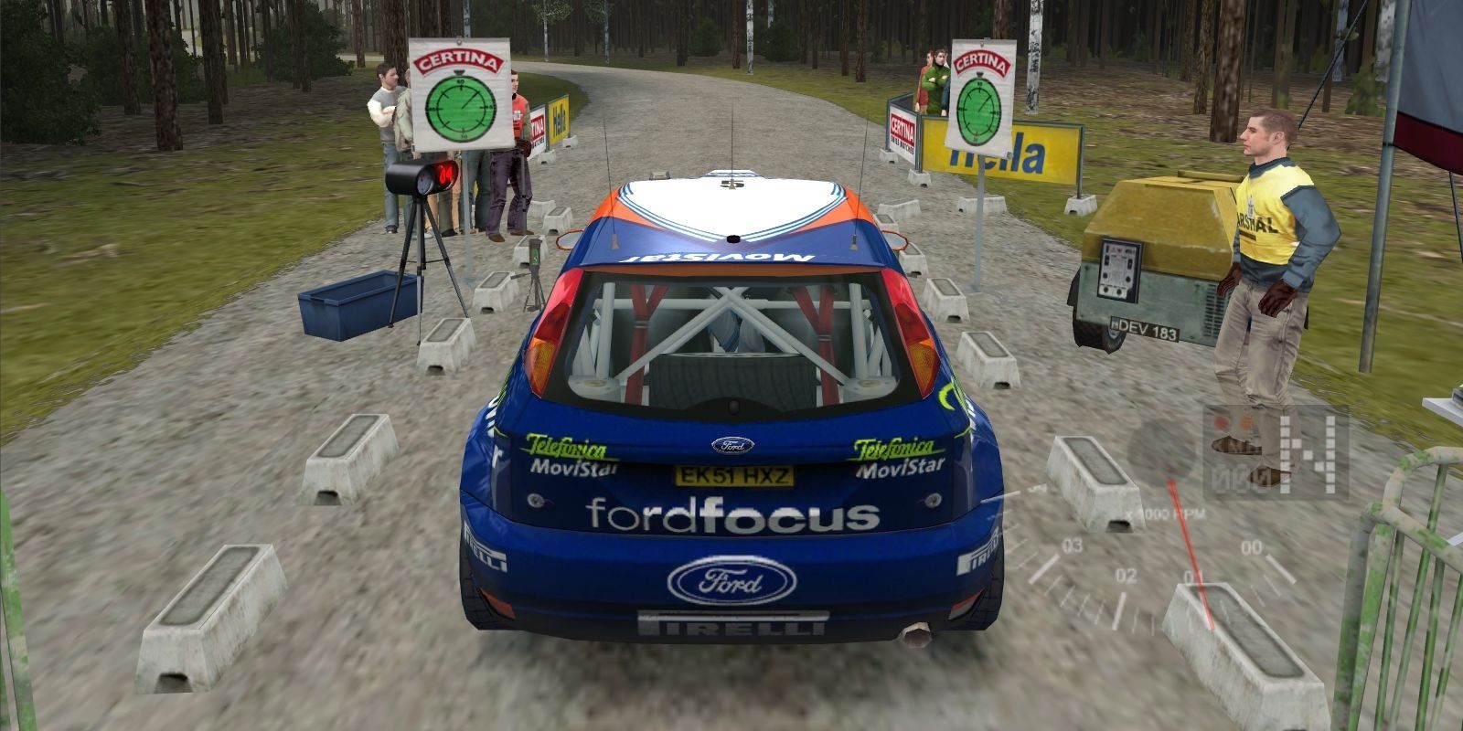 A vehicle sitting in the starting position on a dirt road with "Ford Focus" printed on the back in Colin McRae Rally 3