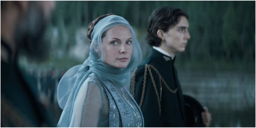 Lady Jessica looks in Duke Leto's direction and Paul Atreides stands nearby in Dune.