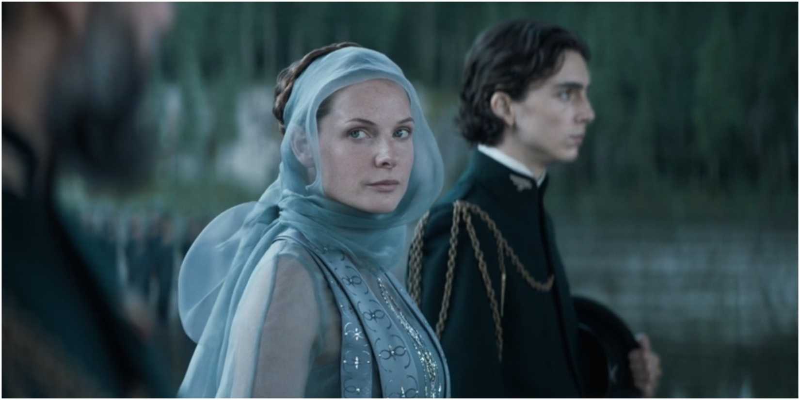 Lady Jessica looks in Duke Leto's direction and Paul Atreides stands nearby in Dune.