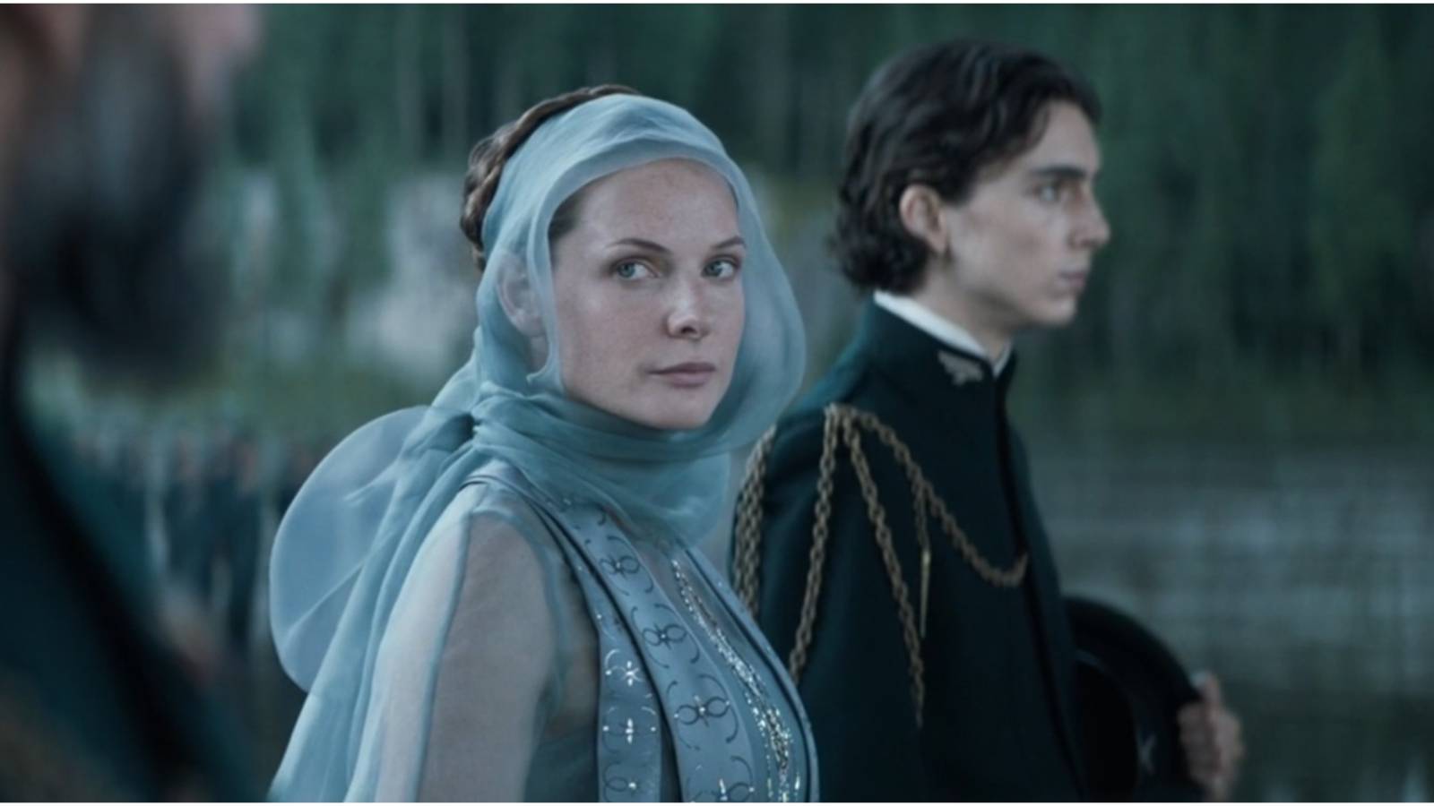 Lady Jessica looks in Duke Leto's direction and Paul Atreides stands nearby in Dune.