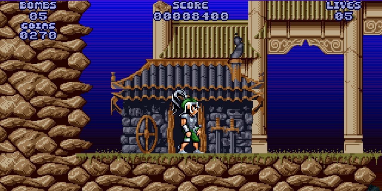 Leander stands in front of a small hit with a rocky wall behind him