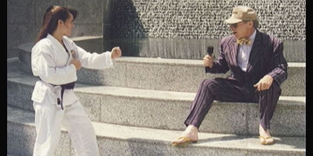 woman in a combat pose and man with a microphone