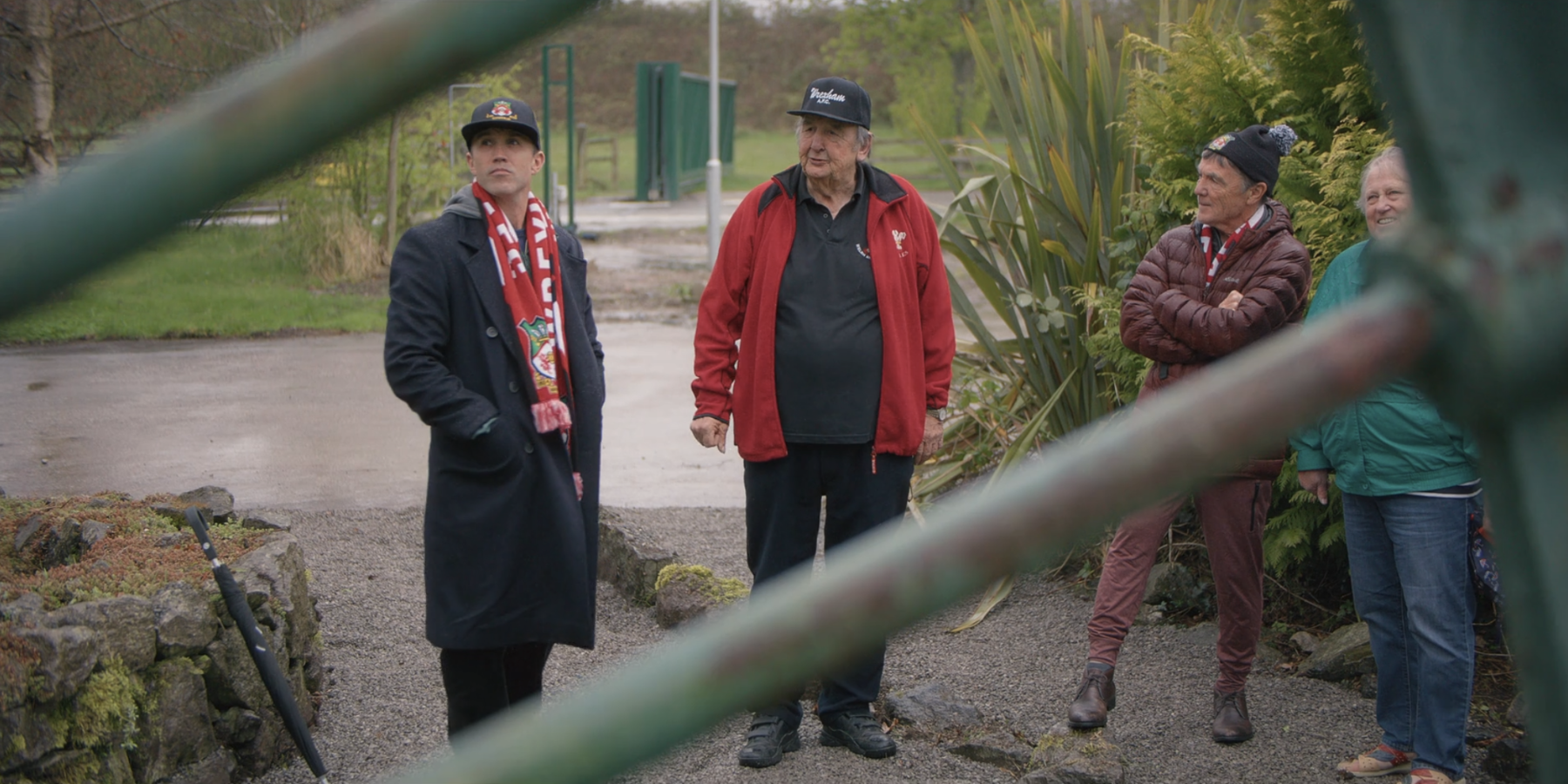 Rob McElhenny and Wrexham residents standing in front of colliery wheel.