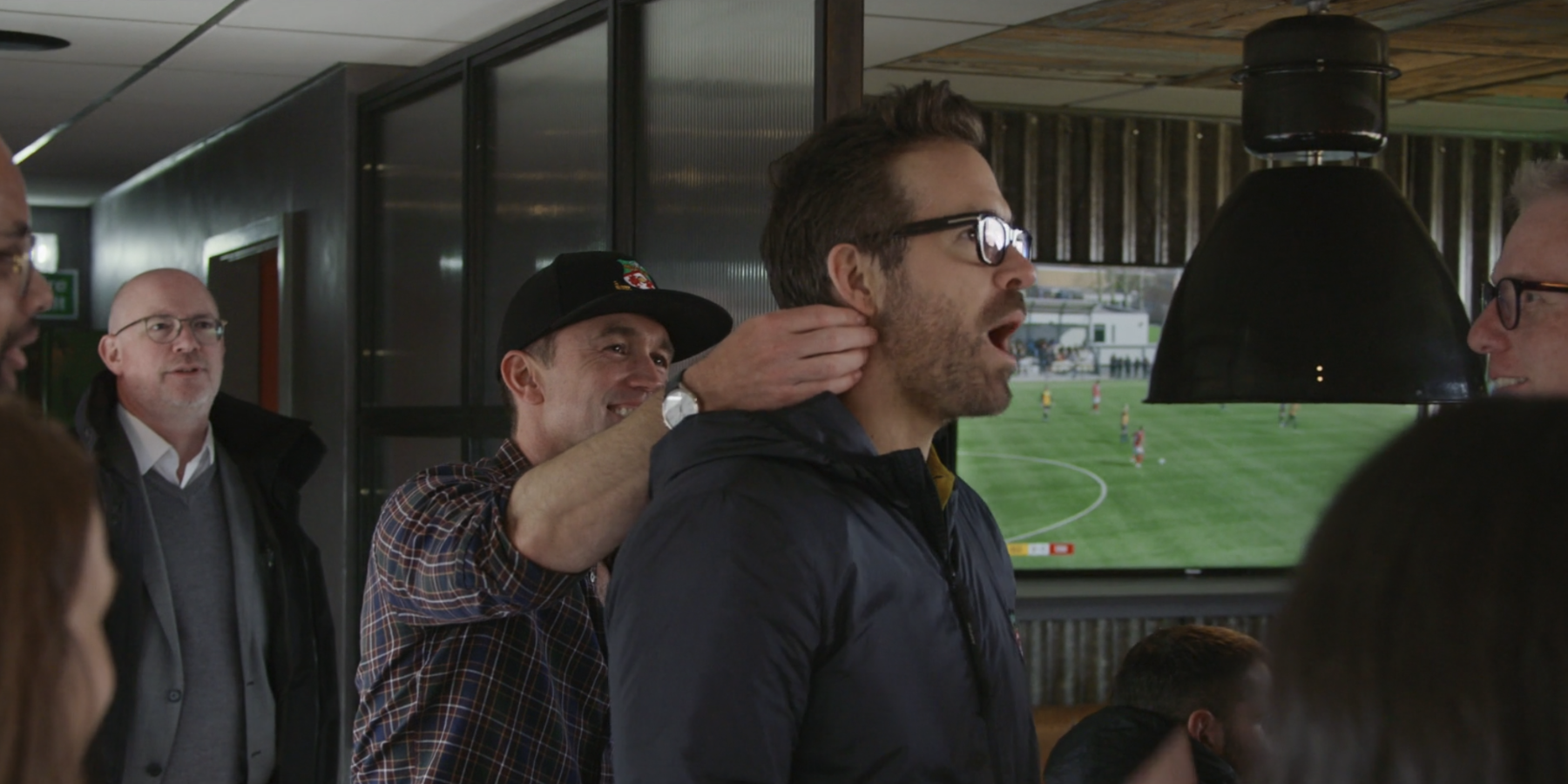 Rob McElhenney jokingly rubbing Ryan Reynolds' neck in Welcome to Wrexham.