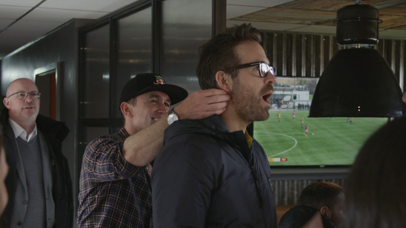 Rob McElhenney jokingly rubbing Ryan Reynolds' neck in Welcome to Wrexham.