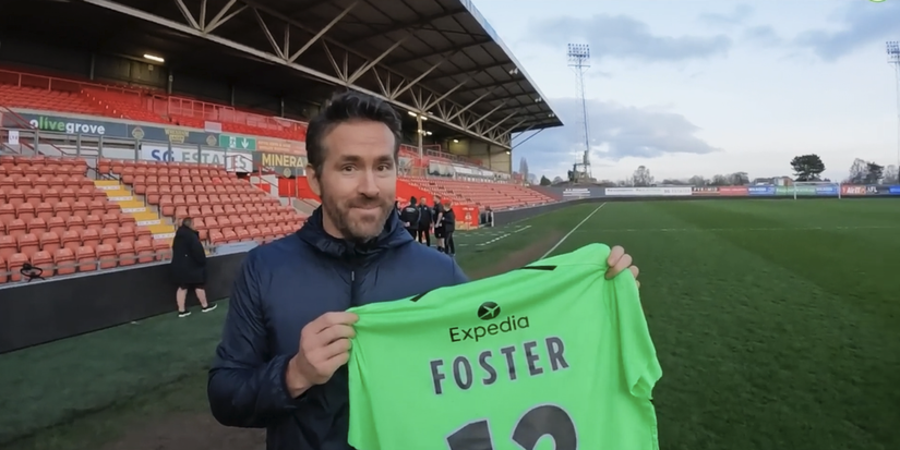 Ryan Reynolds holding Ben Foster shirt after Wrexham match.