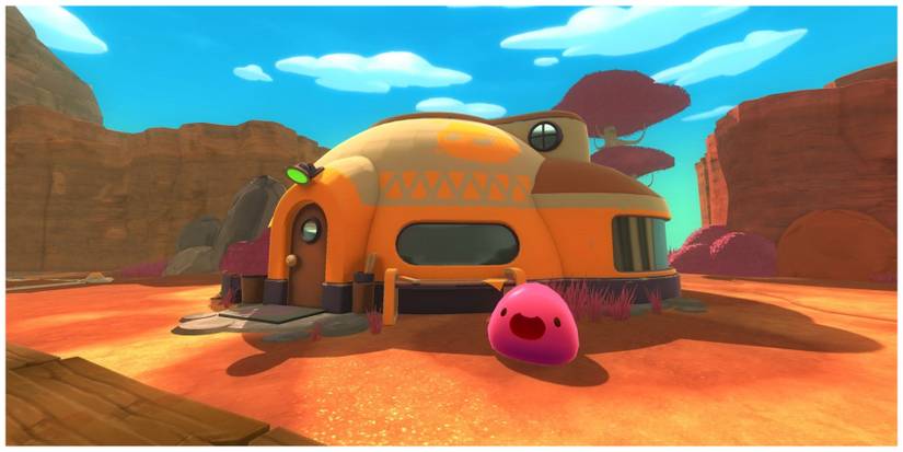 A happy pink slime in front of a yellow hut in a desert in Slime Rancher
