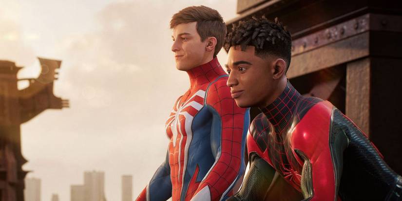 A screenshot of Peter Parker and Miles Morales hanging out above New York City with thier masks off in Marvel's Spider-Man 2.