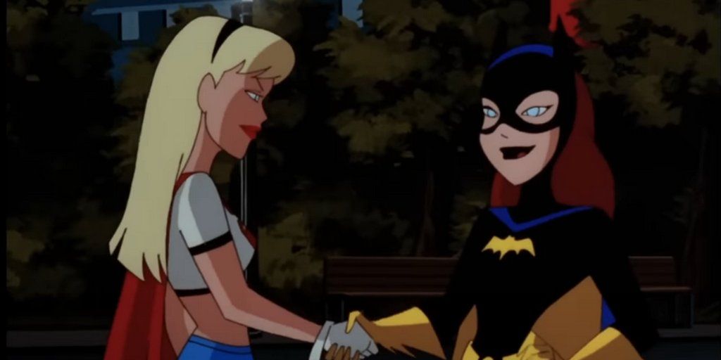 An image of Supergirl and Batgirl shaking hands 