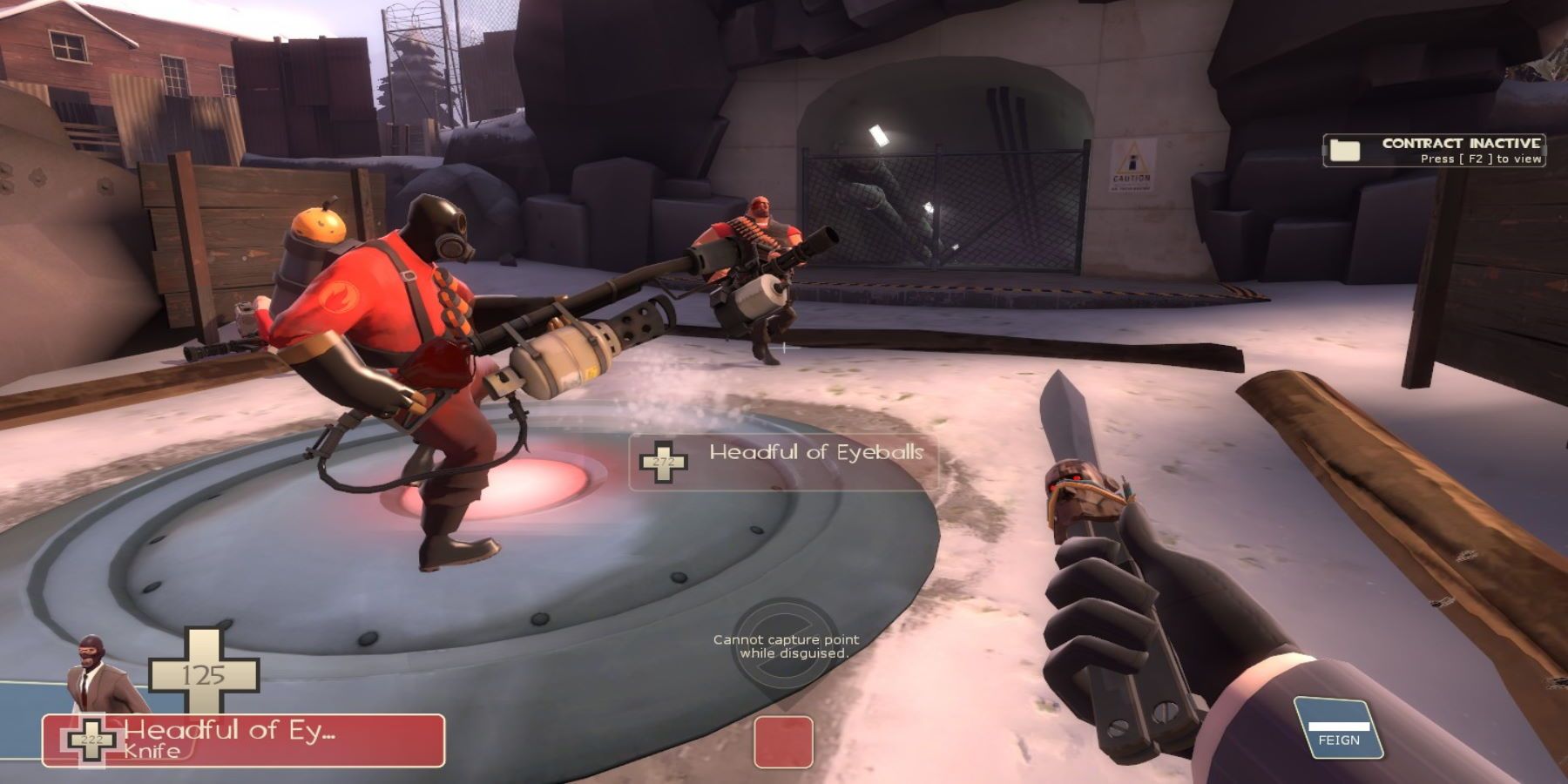 A Spy holding a knife on a capture point near a Pyro and Heavy