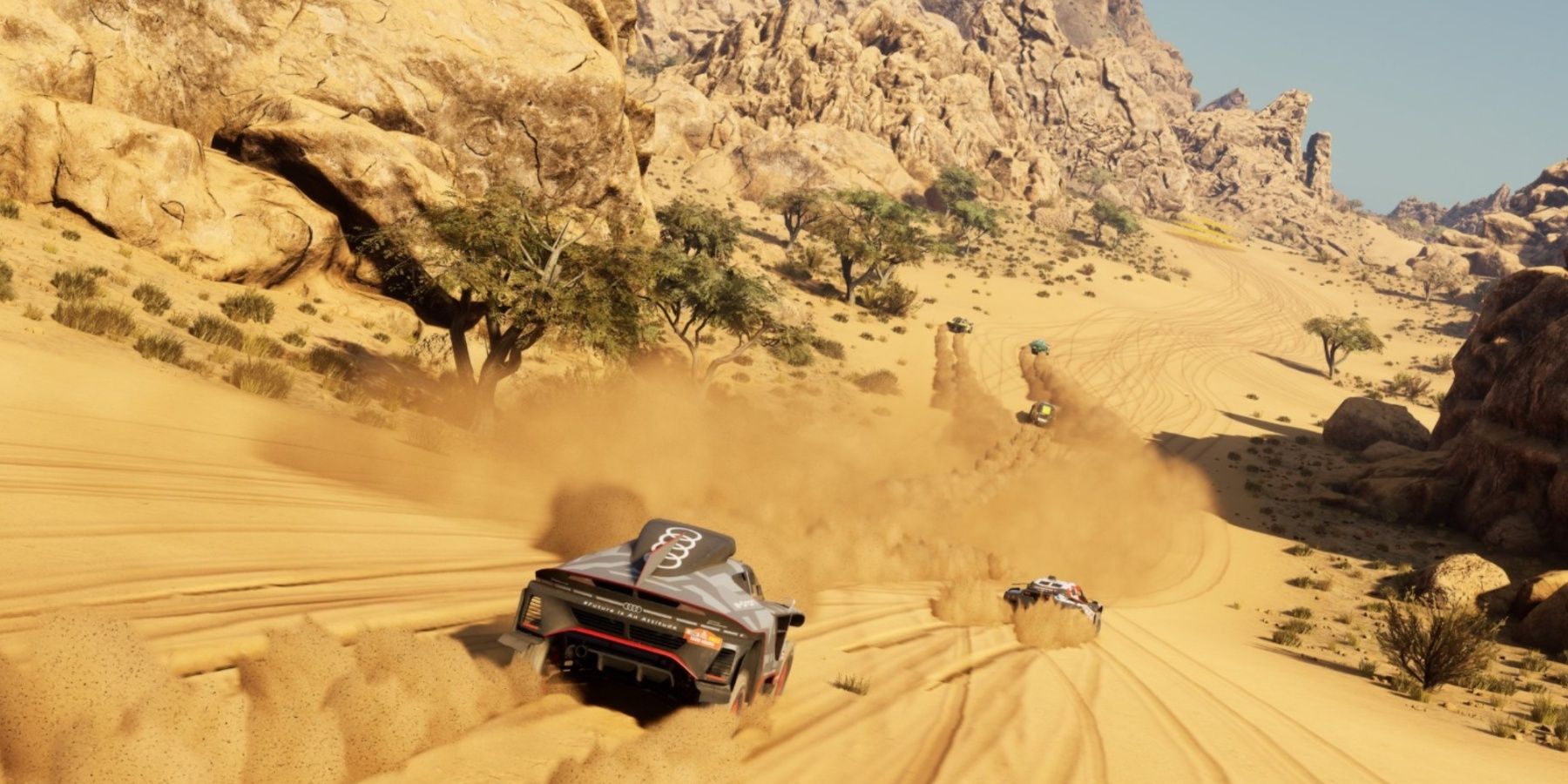Un coche corriendo por una duna de arena con arena ondeando detrás
