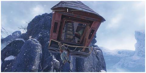 A man hanging from a train car which has gone over a cliff