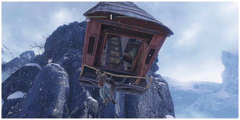 A man hanging from a train car which has gone over a cliff