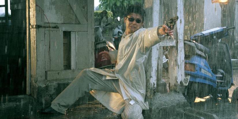 Man in rain pointing a gun