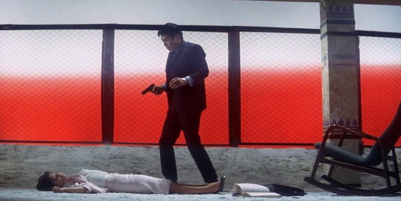 Man standing over body with gun