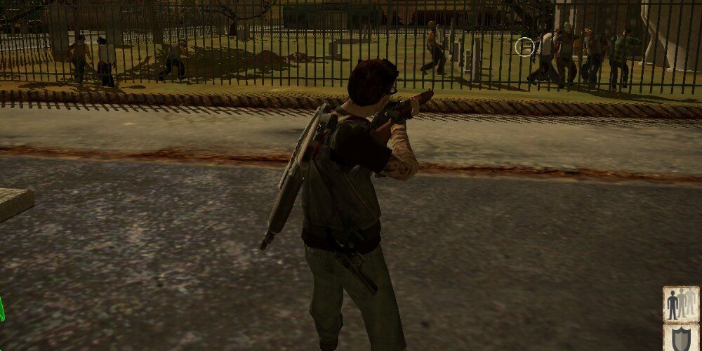 Survivor shooting a shotgun at zombies through a fence