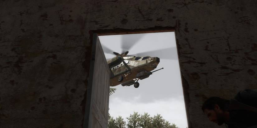 Big Boss hiding from an attack helicopter in Metal Gear Solid 5