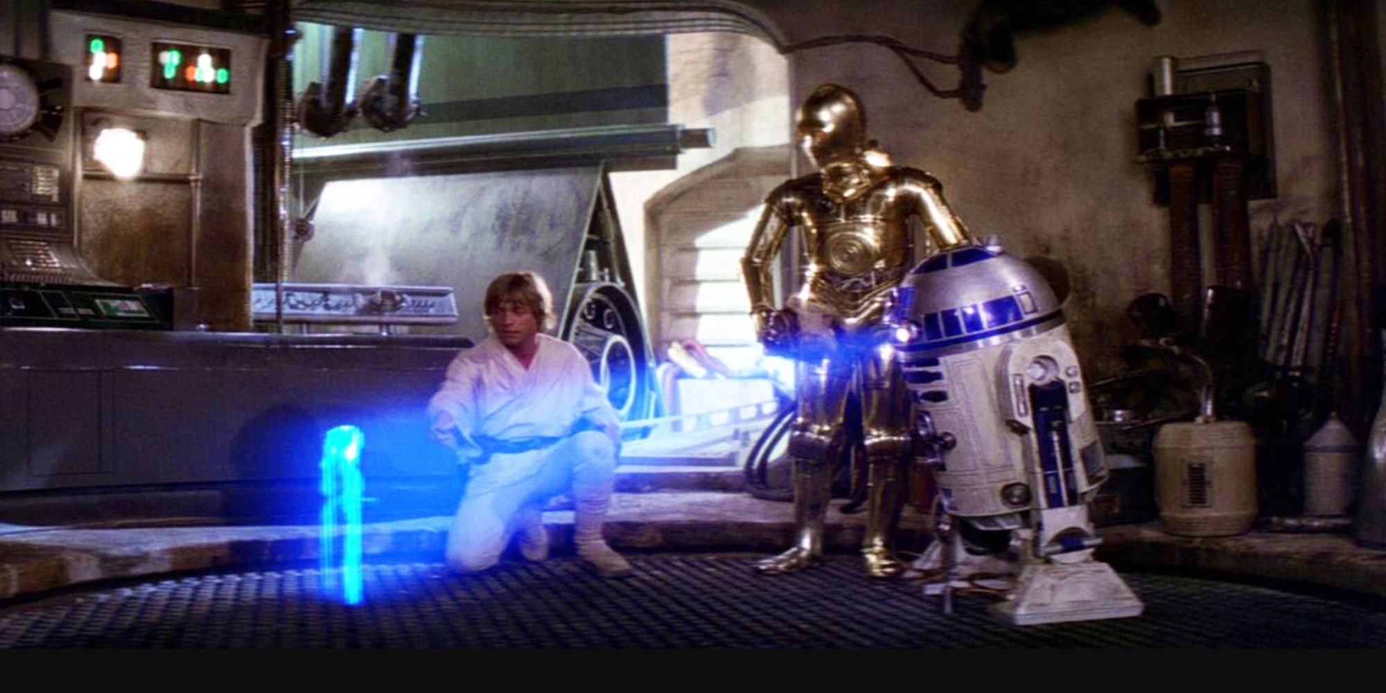 R2-D2 displays Leia's message in a hologram in front of Luke Skywalker and C-3P0
