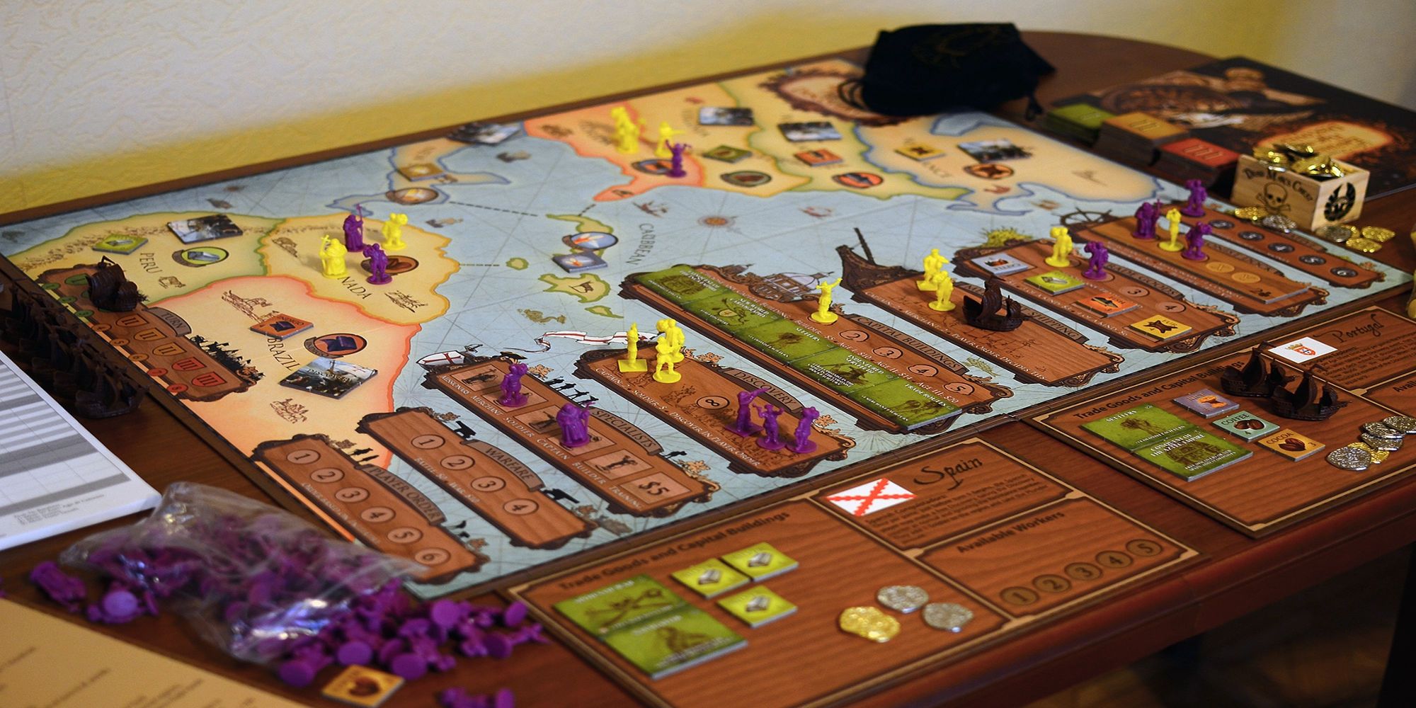 The Age of Empires board game displaying the Americas with purple and yellow figures placed on it