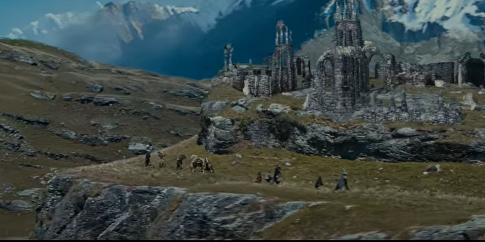 The Fellowship of the Ring walking past some ruins in a line