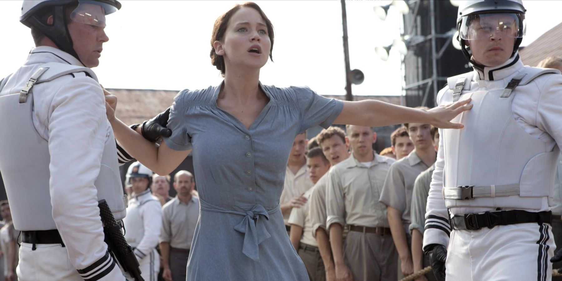 Katniss pushes away two guards as she volunteers for the Hunger Games in place of her sister Prim