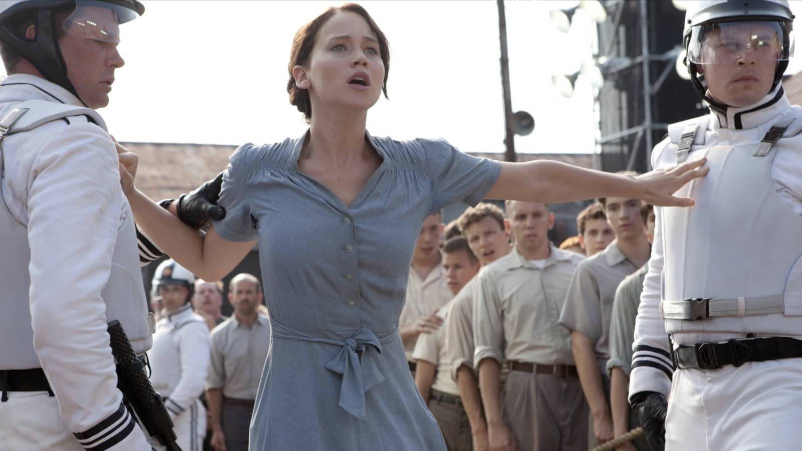 Katniss pushes away two guards as she volunteers for the Hunger Games in place of her sister Prim